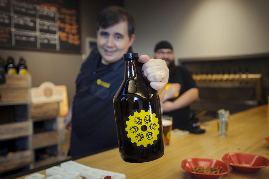 Man reaching out with full growler of beer  