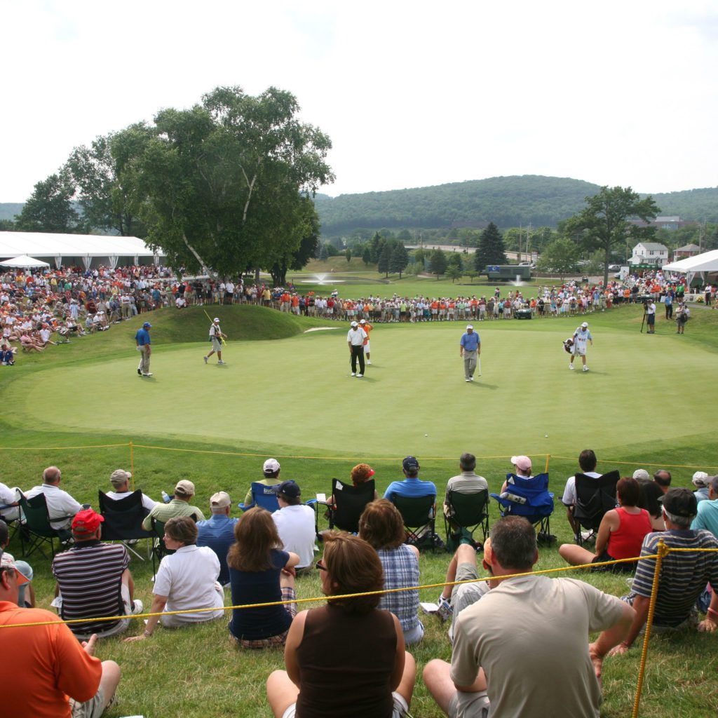 Golfers at the DICK'S Sporting Goods Open with a crowd watching.
