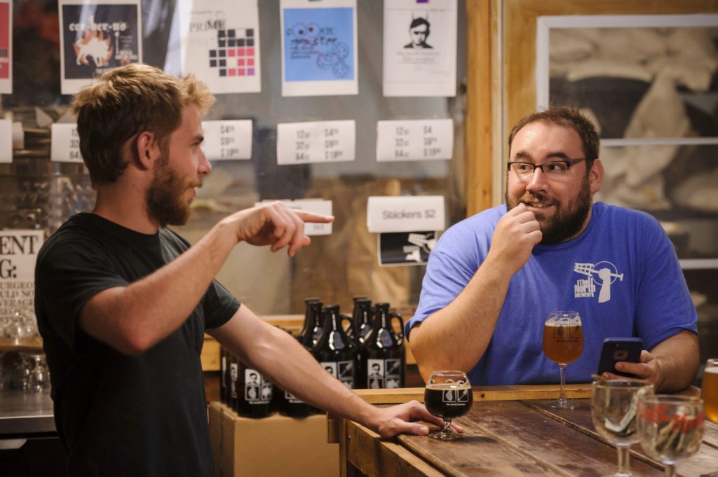2 men enjoying beer at brewery
