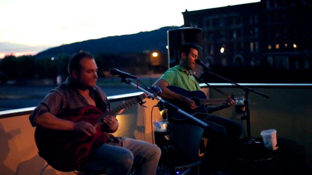 Two musician performing on rooftop patio