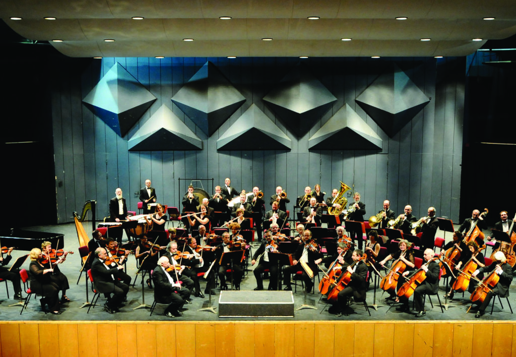 Musicians play in an orchestra shell.