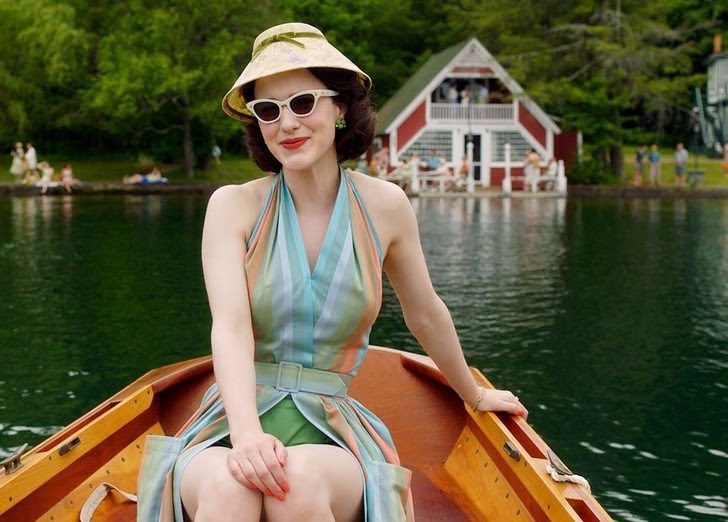 Shot of smiling woman from The Marvelous Mrs. Maisel in boat on water.