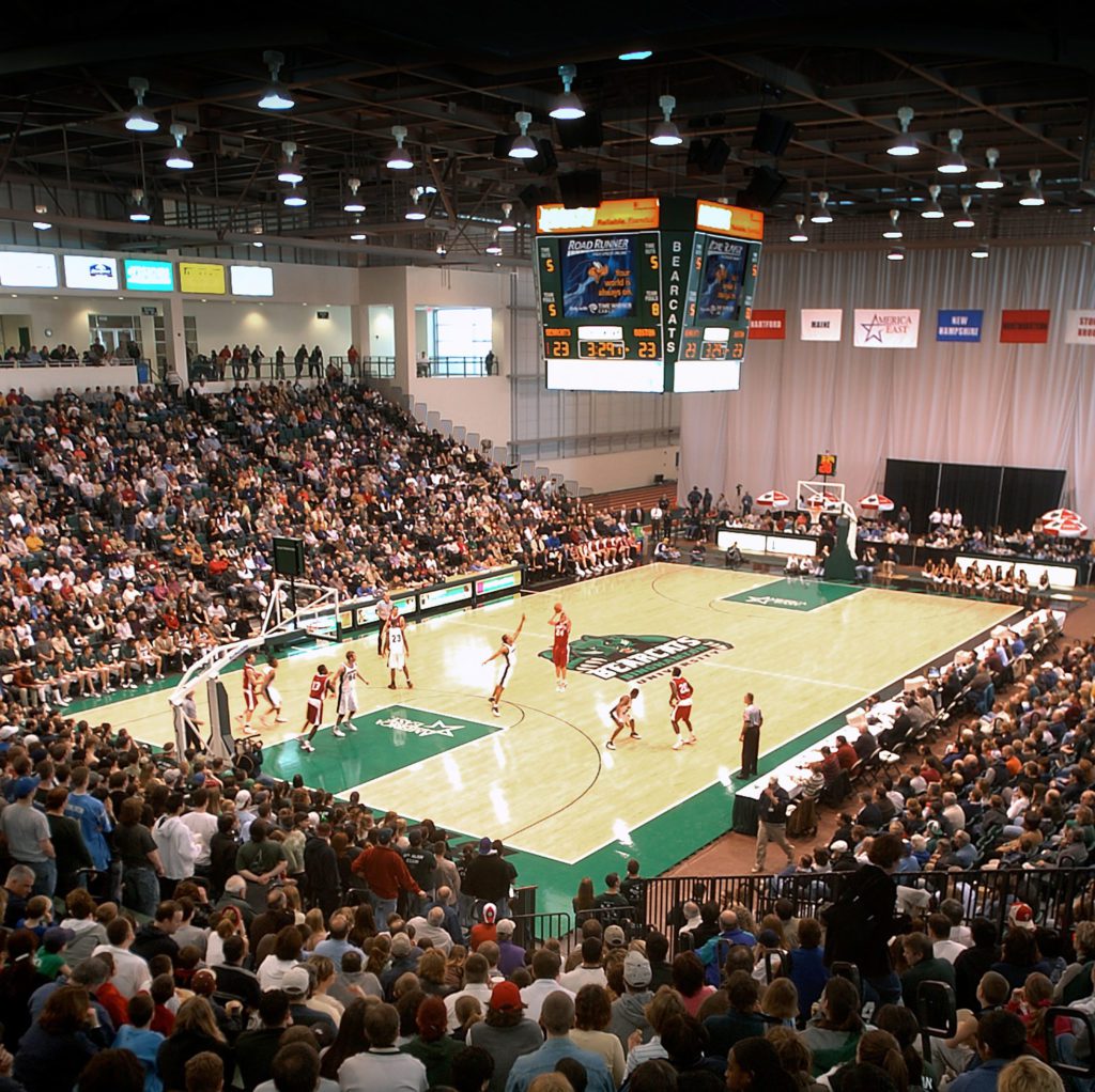 Basketball arena with a large crowd watching.